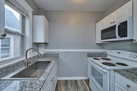 a kitchen with a sink stove and microwave