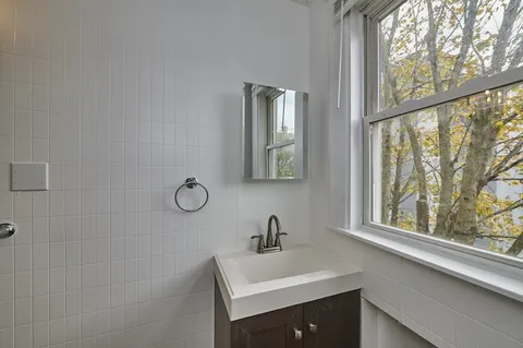 a bathroom with a sink mirror and a window