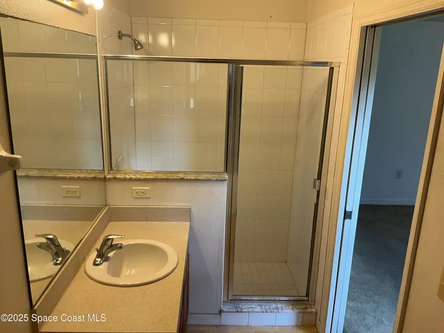 a bathroom with a sink a mirror and shower