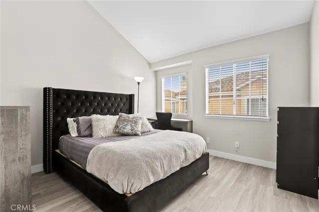 a bedroom with a bed and wooden floor