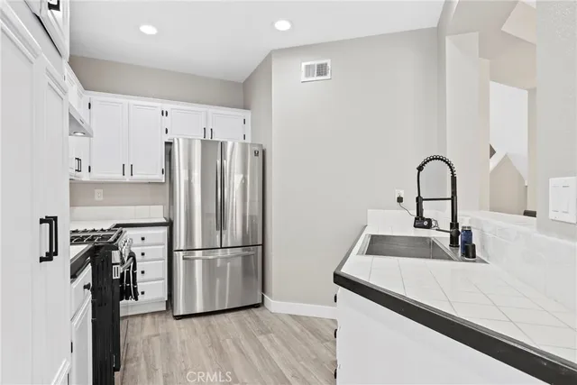 a kitchen with a refrigerator sink and wooden floor