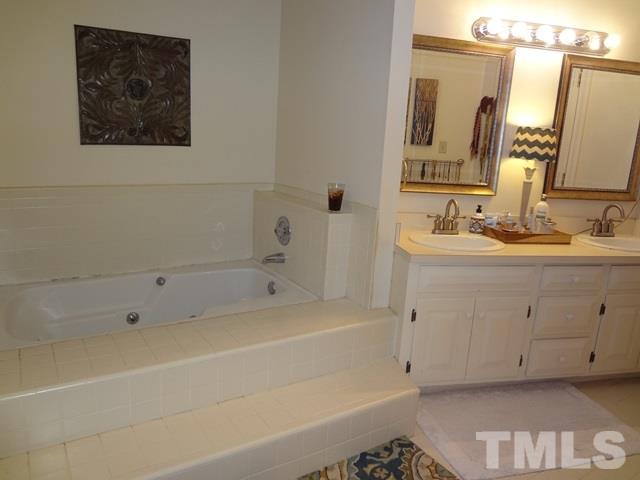 1400 October Road Raleigh, NC 27614 - Photo 13 of 25 a bathroom with a tub a sink and mirror