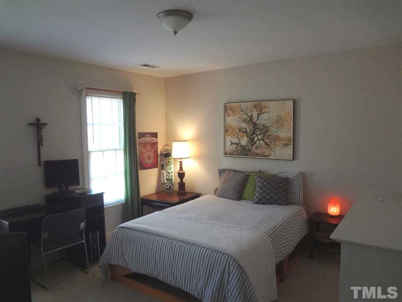 1400 October Road Raleigh, NC 27614 - Photo 17 of 25 a bedroom with a bed and a flat tv screen on a dresser