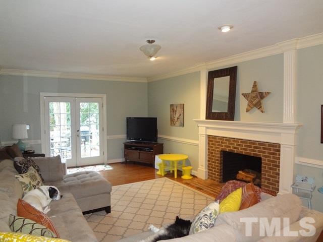 1400 October Road Raleigh, NC 27614 - Photo 4 of 25 a living room with furniture a fireplace and a flat screen tv