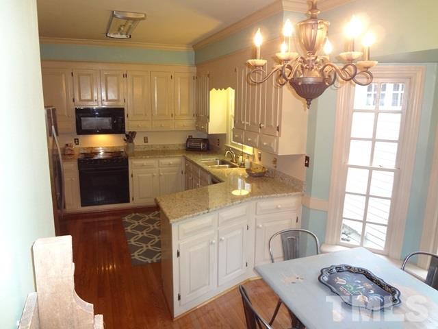 1400 October Road Raleigh, NC 27614 - Photo 7 of 25 a kitchen with a sink cabinets a stove and a window