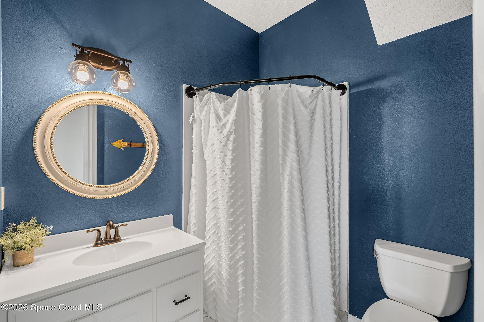 4010 Turkey Point Drive Melbourne, FL 32934 - Photo 31 of 53 a bathroom with a toilet sink and mirror