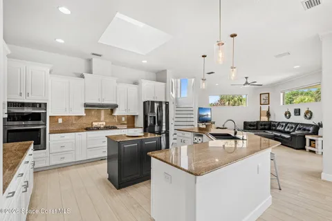 a kitchen with kitchen island granite countertop a sink counter top space appliances and cabinets