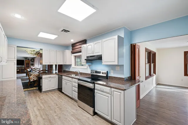 a kitchen with white cabinets and appliances