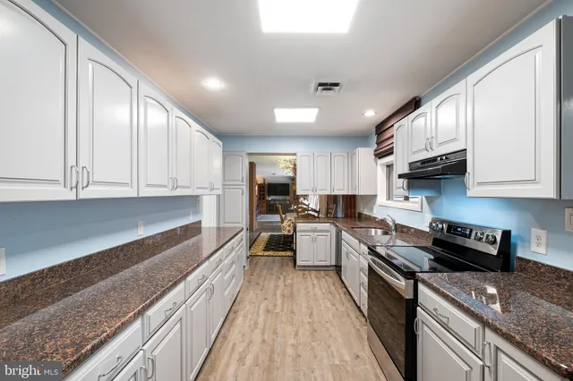 a large kitchen with stainless steel appliances granite countertop lots of counter space a sink and dishwasher