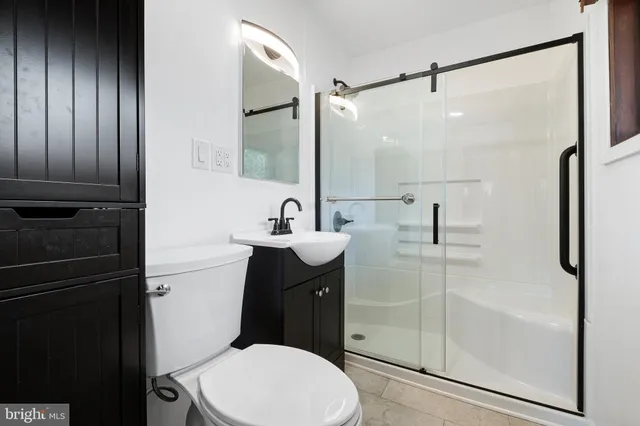 a bathroom with a sink a toilet and shower