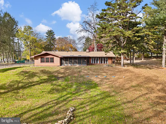 a front view of house with yard and trees around
