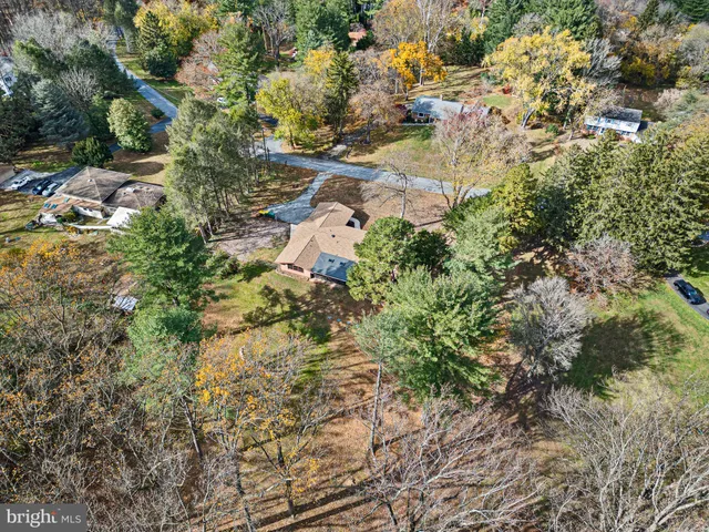an aerial view of residential house with parking and trees