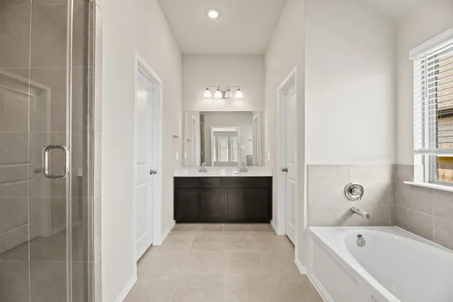 a bathroom with a bathtub shower and sink