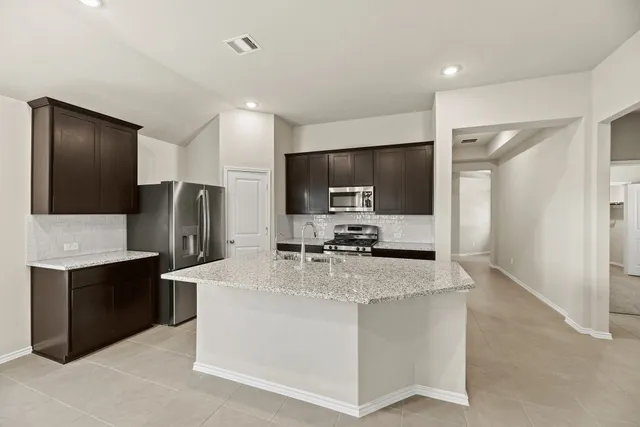 a kitchen with stainless steel appliances a refrigerator sink and microwave