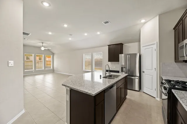 a kitchen with stainless steel appliances granite countertop a sink stove and refrigerator