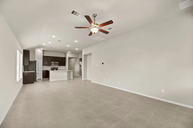 a view of kitchen with refrigerator stove and a ceiling fan