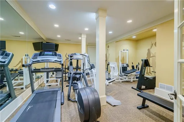 a front view of a house with garden and trees