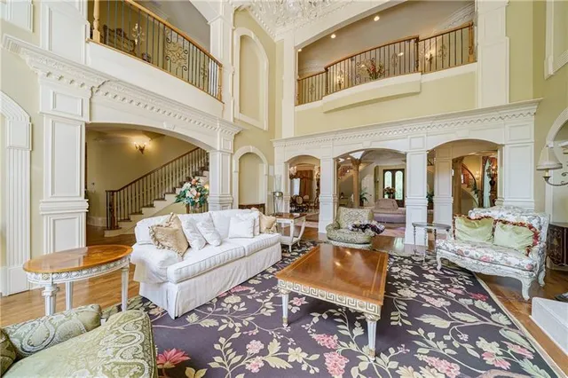 a living room with furniture a fireplace and a chandelier