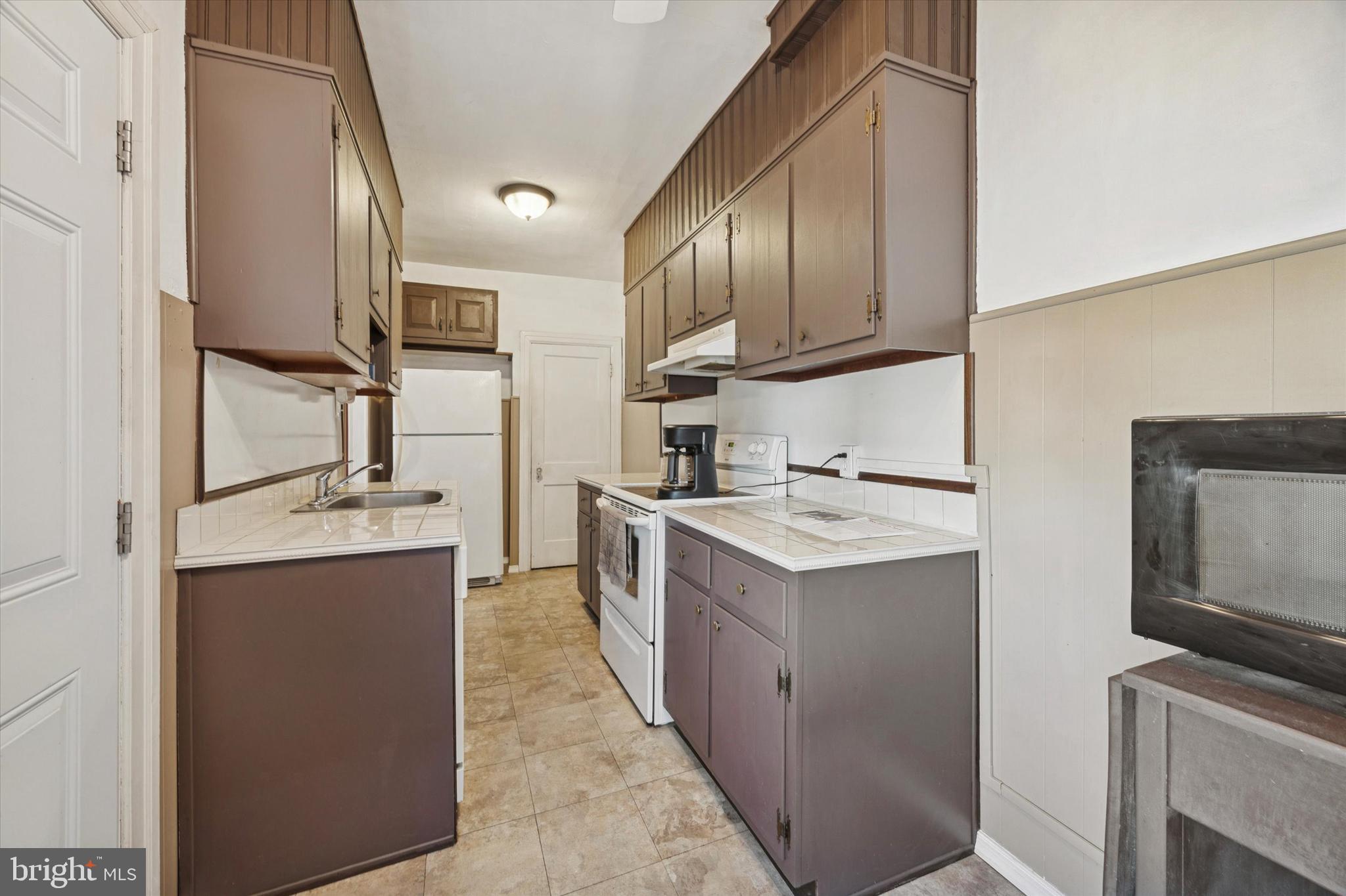 1114 Roosevelt Drive Havertown, PA 19083 - Photo 5 of 14 a kitchen with stainless steel appliances granite countertop a sink stove and refrigerator
