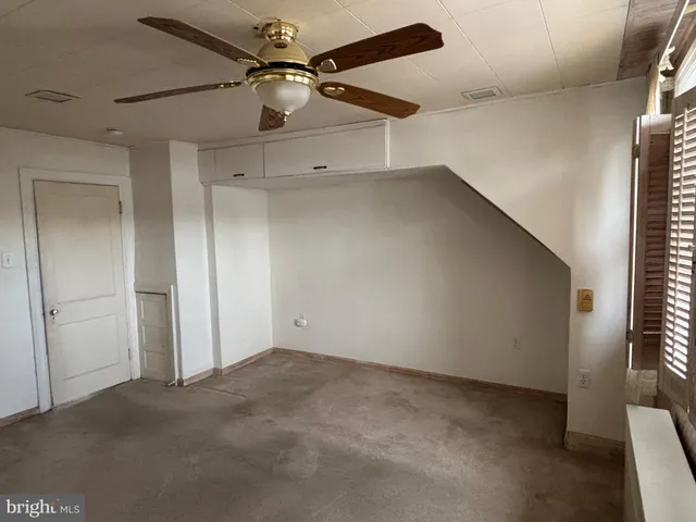 en empty room with windows and fan