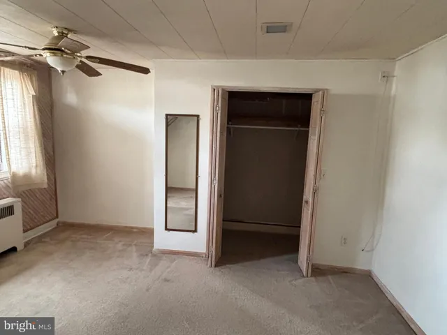an empty room with windows and closet