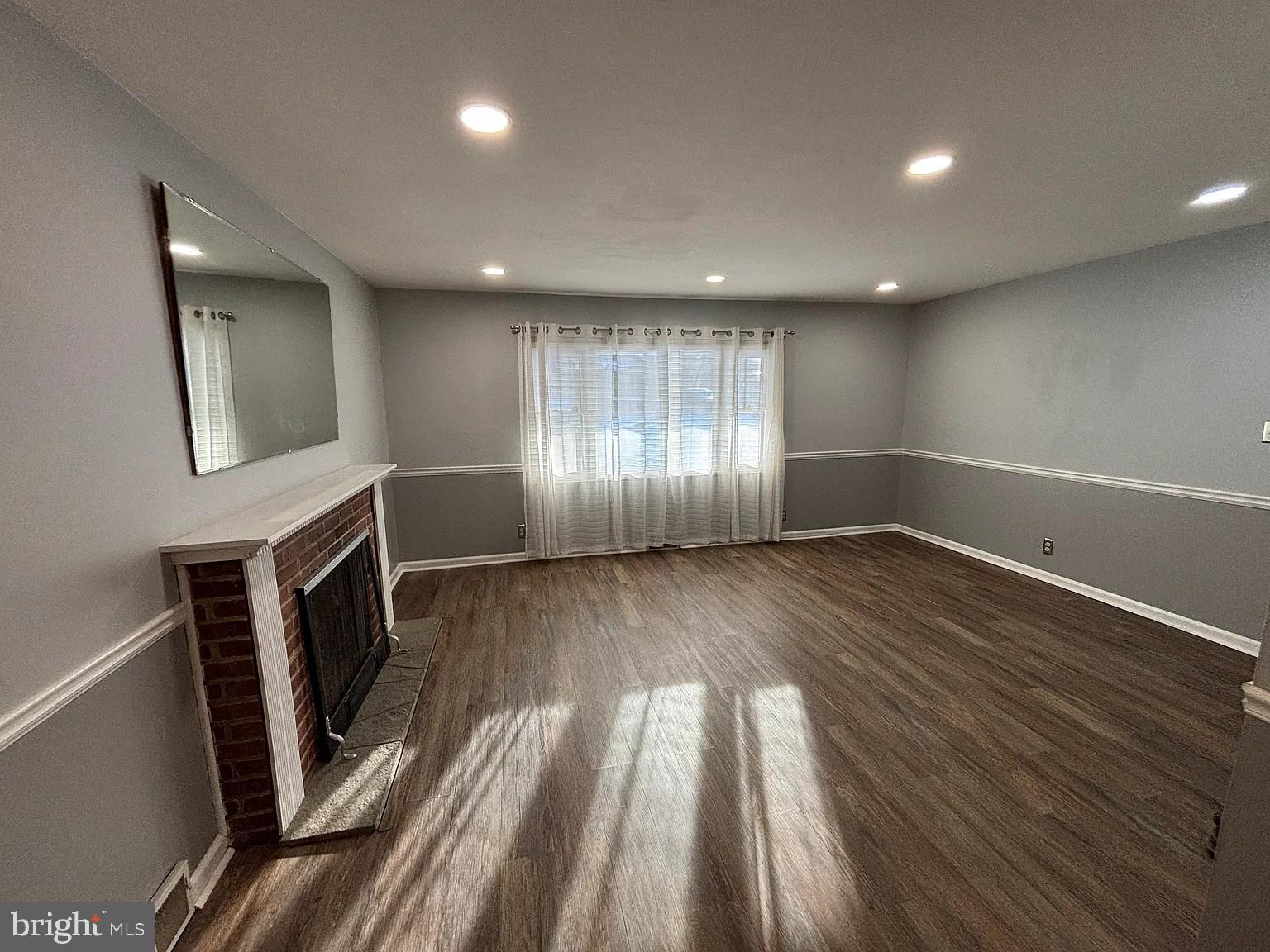 336 Hillside Road King of Prussia, PA 19406 - Photo 8 of 17 an empty room with wooden floor and fireplace