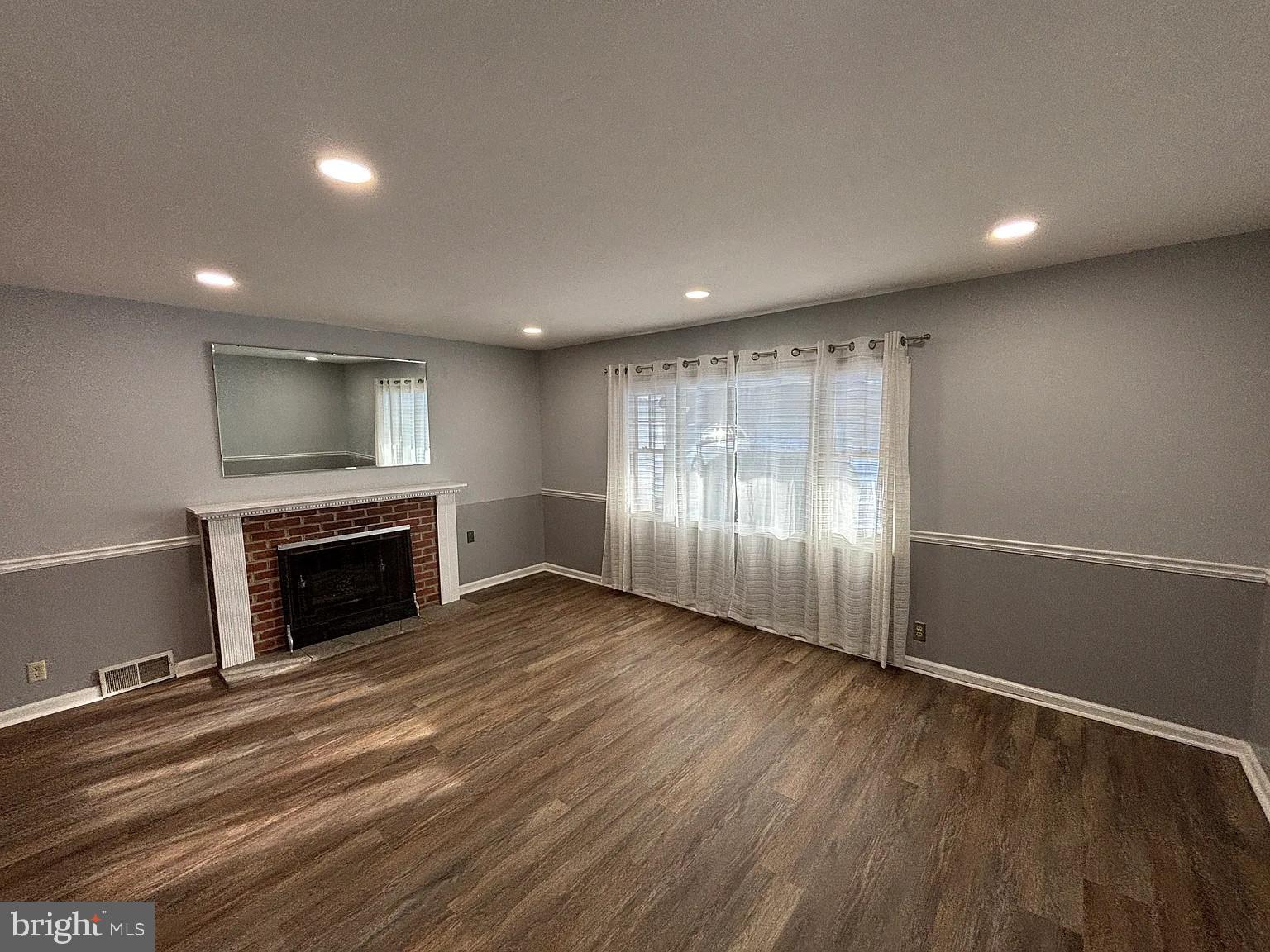 336 Hillside Road King of Prussia, PA 19406 - Photo 9 of 17 an empty room with wooden floor fireplace and windows