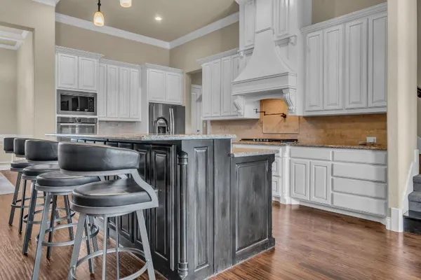 a kitchen with stainless steel appliances a stove a sink dishwasher and wooden cabinets