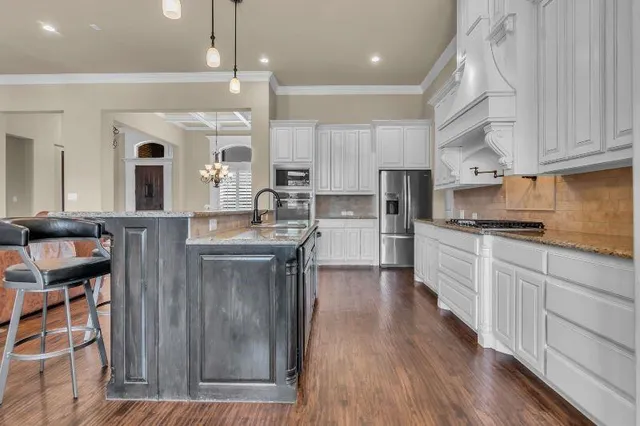a kitchen with cabinets a sink and stainless steel appliances