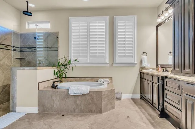 a bathroom with a tub sink and mirror