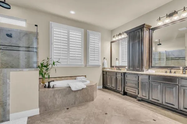 a large spacious bathroom with a double vanity sink a large mirror and a bathtub