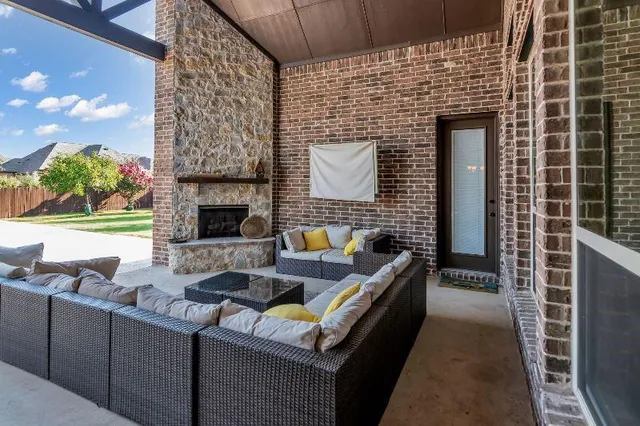 a view of a patio with couches and a fireplace