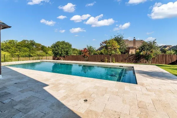 a view of a house with swimming pool next to a yard
