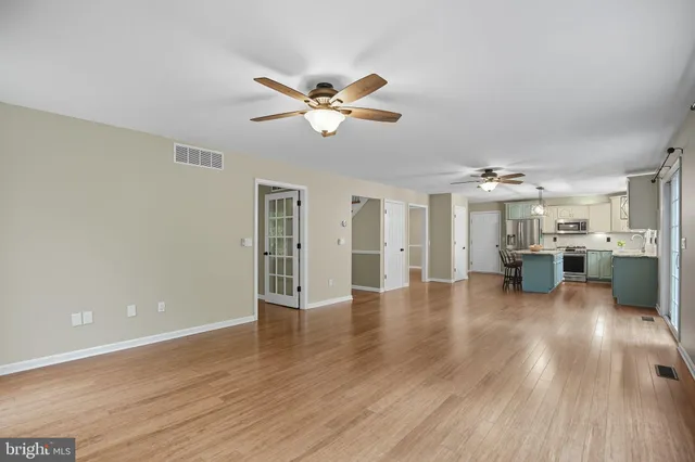 a view of a livingroom with wooden floor and a ceiling fan