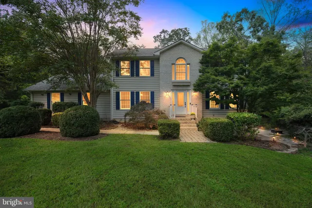 a front view of a house with a yard and trees