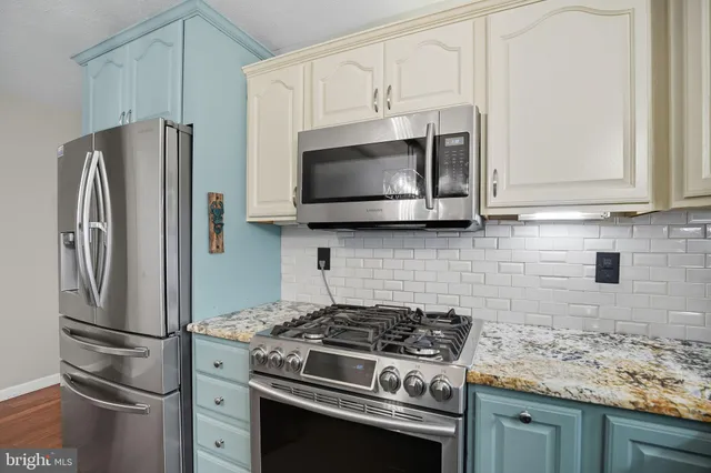 a kitchen with stainless steel appliances wooden cabinets and a stove top oven