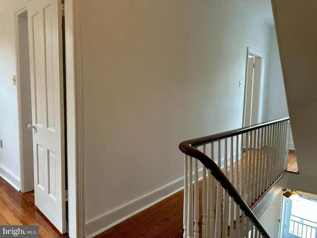a view of a hallway with wooden floor and stairs