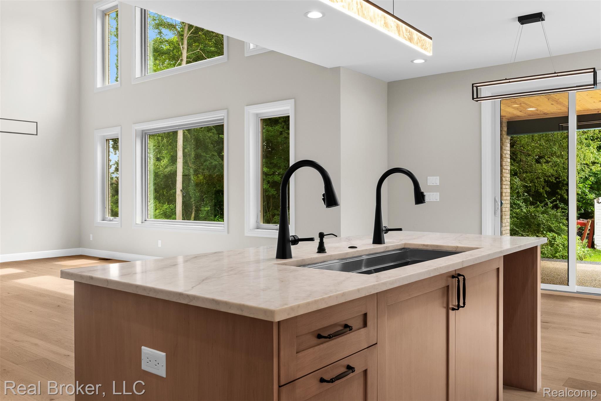 12114 22 Mile Road Utica, MI 48315 - Photo 21 of 70 Kitchen island with integrated double basin sink, light-toned countertop, and matte black faucets