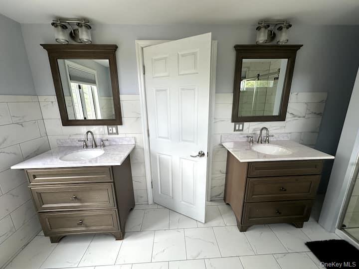 84 Mongaup Road Hurleyville, NY 12747 - Photo 32 of 50 Dual vanity arrangement featuring dark wood-finish cabinetry, integrated sinks, and polished chrome fixtures
