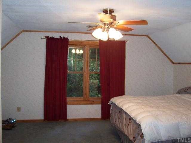 280 Indian Trail Road Timberlake, NC 27583 - Photo 5 of 11 a bedroom with a bed and a chandelier