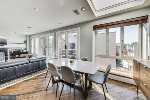 a view of a dining room with furniture large windows and wooden floor