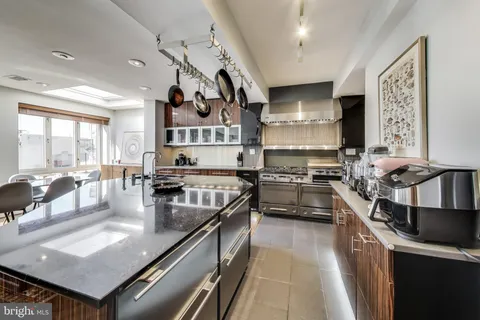 a kitchen with stainless steel appliances granite countertop a stove top oven a sink dishwasher and cabinets with wooden floor