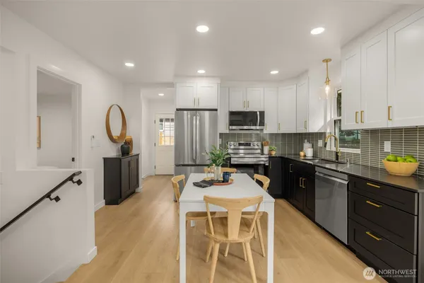 a kitchen with a table chairs refrigerator and microwave