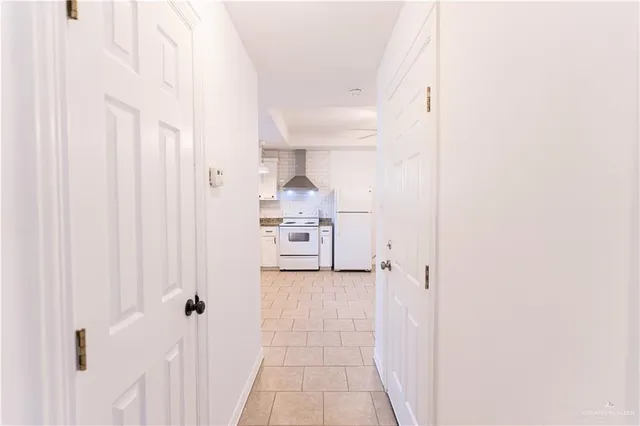 a view of a hallway with two white cabinets