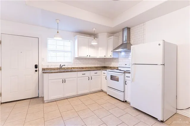 a kitchen with white cabinets and white appliances