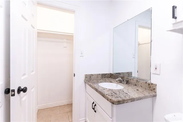 a bathroom with a granite countertop sink and a mirror