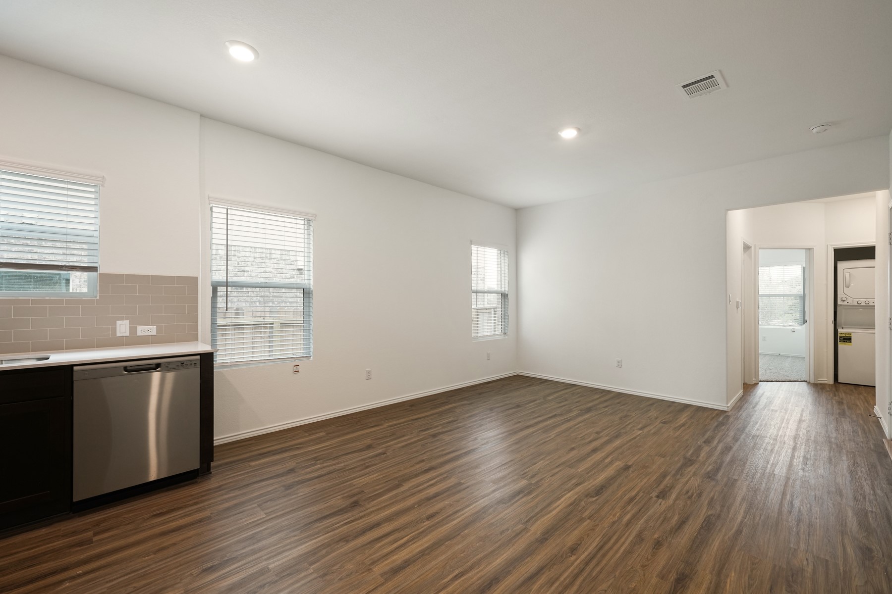 932 Mallow Road Leander, TX 78641 - Photo 6 of 34 A streamlined open-concept space features resilient wood-look flooring and efficient recessed lighting.