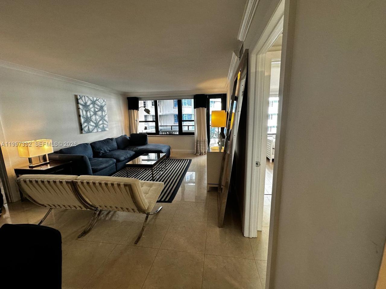 5225 Collins Avenue, Unit 614 Miami Beach, FL 33140 - Photo 1 of 8 a living room with furniture and a potted plant