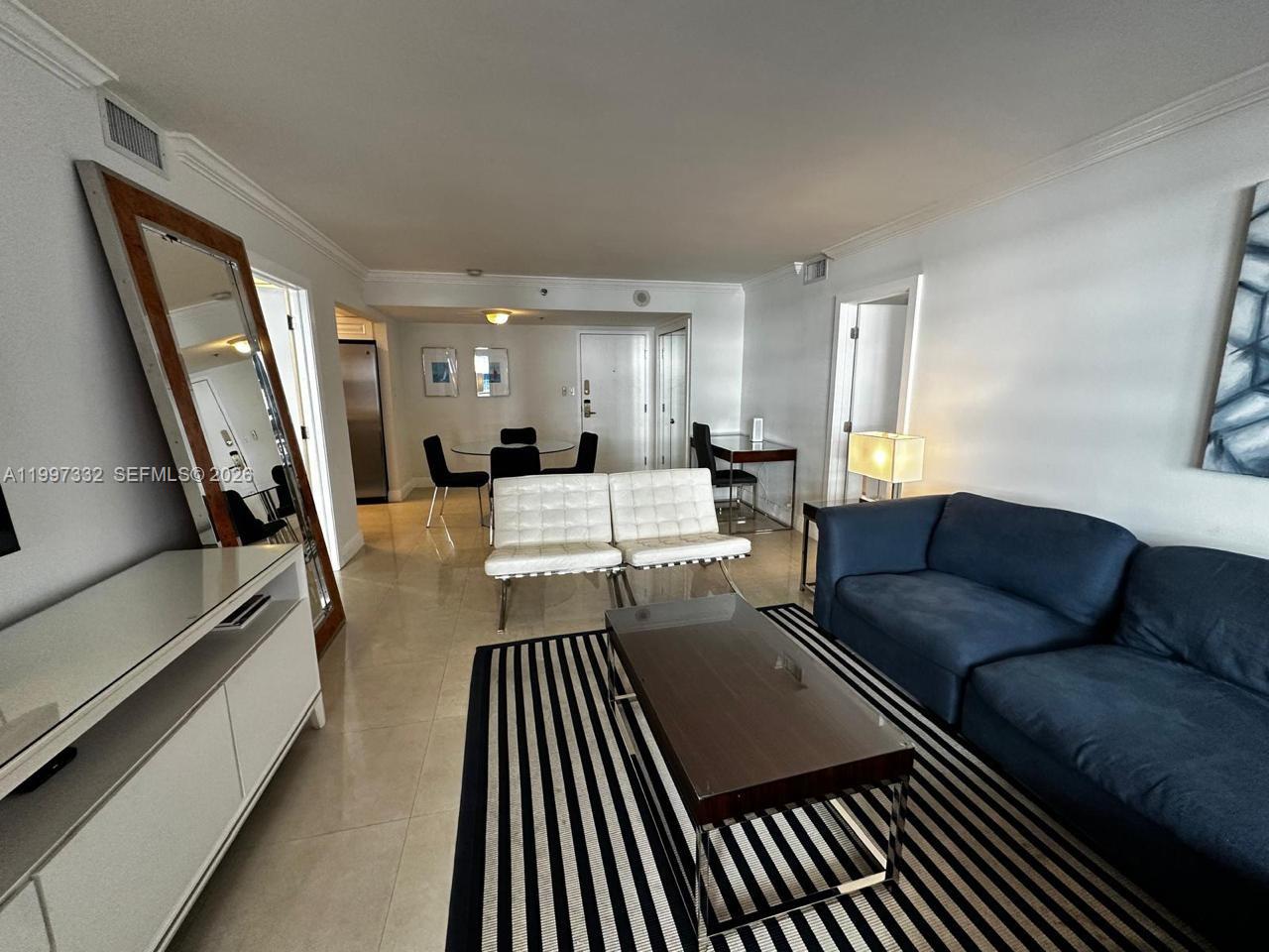 5225 Collins Avenue, Unit 614 Miami Beach, FL 33140 - Photo 4 of 8 a living room with furniture and a wooden floor