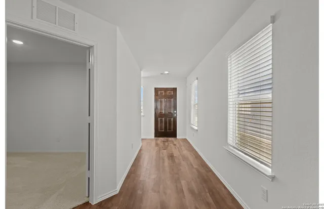 a view of a hallway with wooden floor and staircase